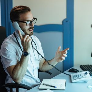 male-doctor-sitting-his-office-communicating-with-someone-phone_637285-5208 male-doctor-sitting-his-office-communicating-with-someone-phone_637285-5208